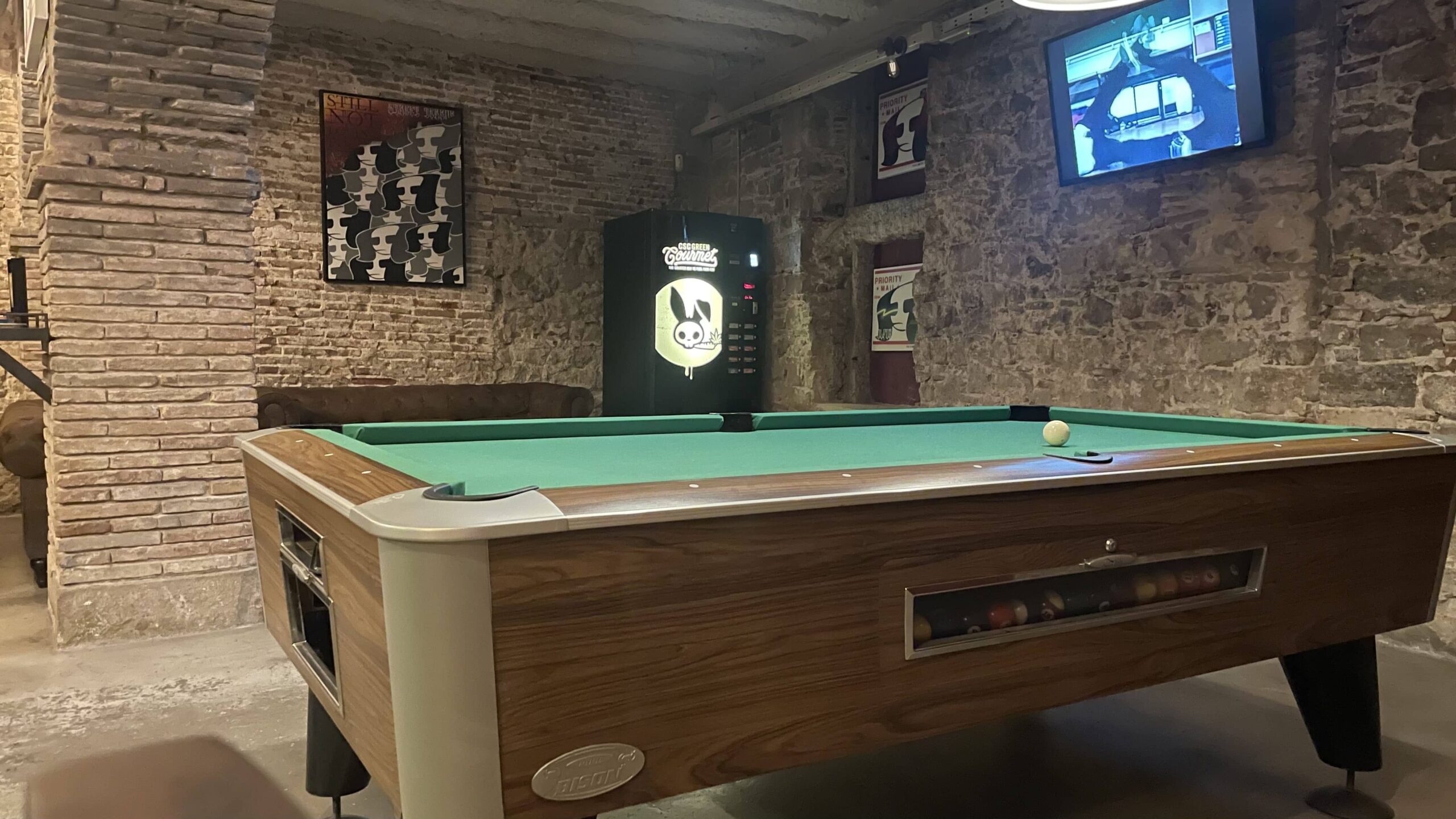 Blunted Social Club in Barcelona decored with paintings and showing pool table